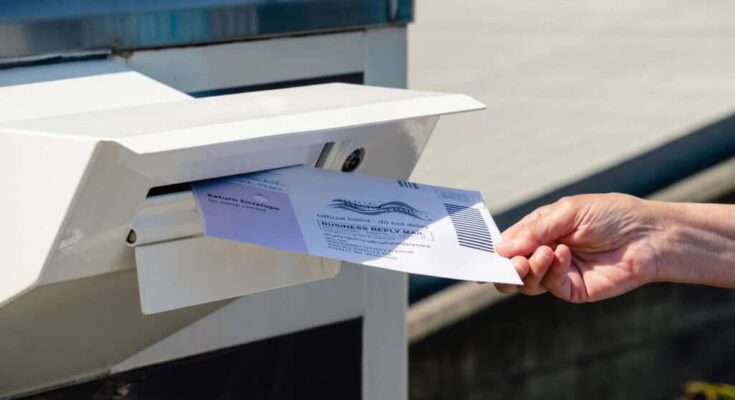 Dropping a mail-in ballot into a mail box. Everett, Washington