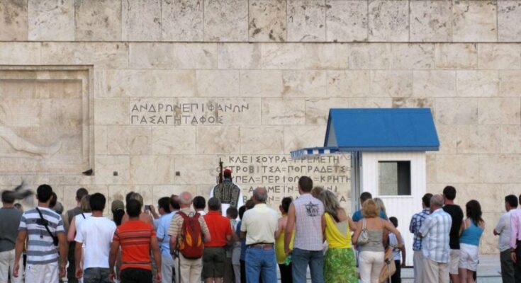 Tourists visiting the Greek Parliament in Athens, highlighting the strong tourist interest in Greece's capital during the fall season.