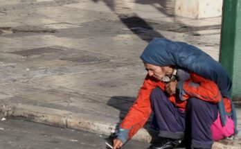 Homeless woman near Syntagma Square on a crisp autumn morning in Athens, reflecting economic hardship in Greece