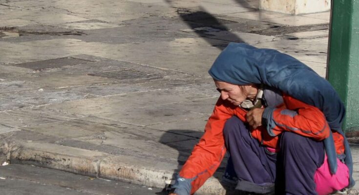 Homeless woman near Syntagma Square on a crisp autumn morning in Athens, reflecting economic hardship in Greece